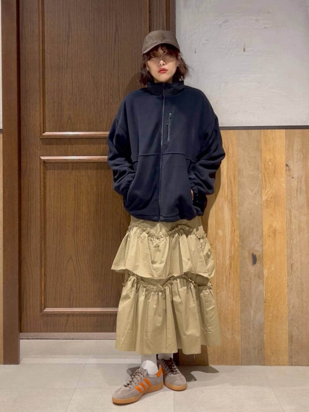 ブルー系のニット/セーター、ベージュ系のスカート、ブルー系のブルゾンを着用したレディースの冬コーディネートの1枚目の写真