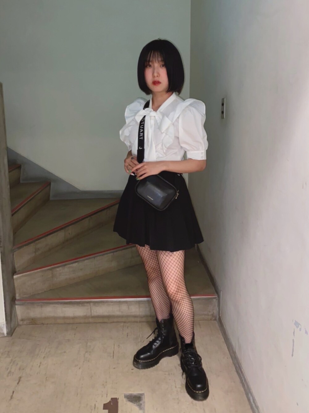 ブラック系のスカート、ブラック系のブーツを着用したレディースの夏コーディネートの1枚目の写真