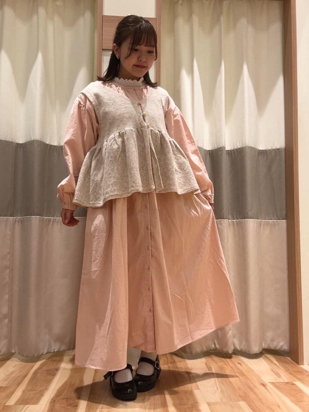 ピンク系のワンピース、ベージュ系のトップス、ホワイト系のシャツ/ブラウスを着用したレディースの冬コーディネートの1枚目の写真