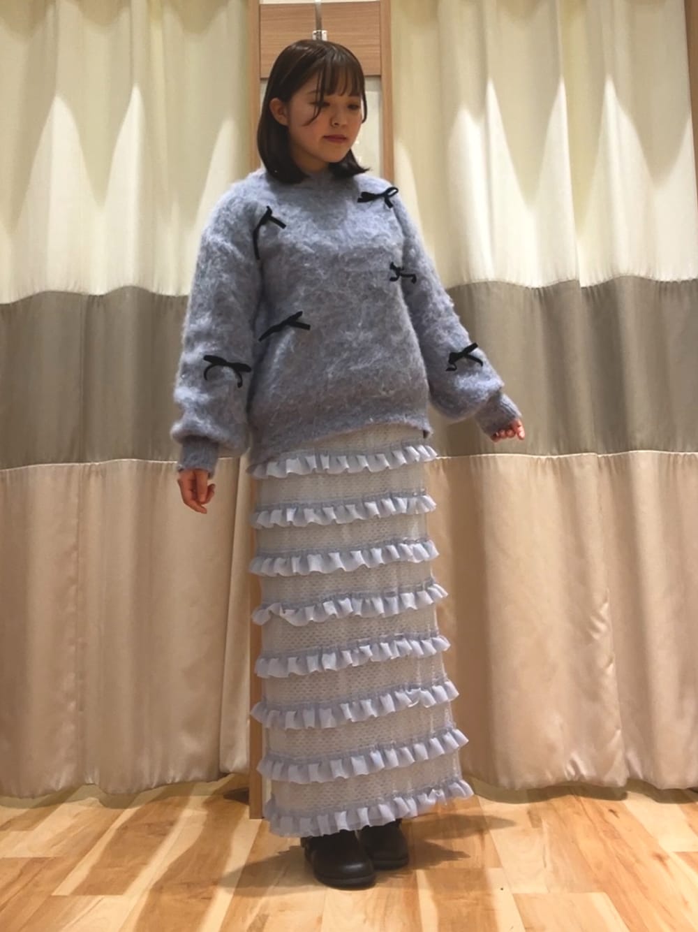 ブルー系のニット/セーター、ブルー系のスカート、ブラック系のドレスシューズを着用したレディースの冬コーディネートの1枚目の写真