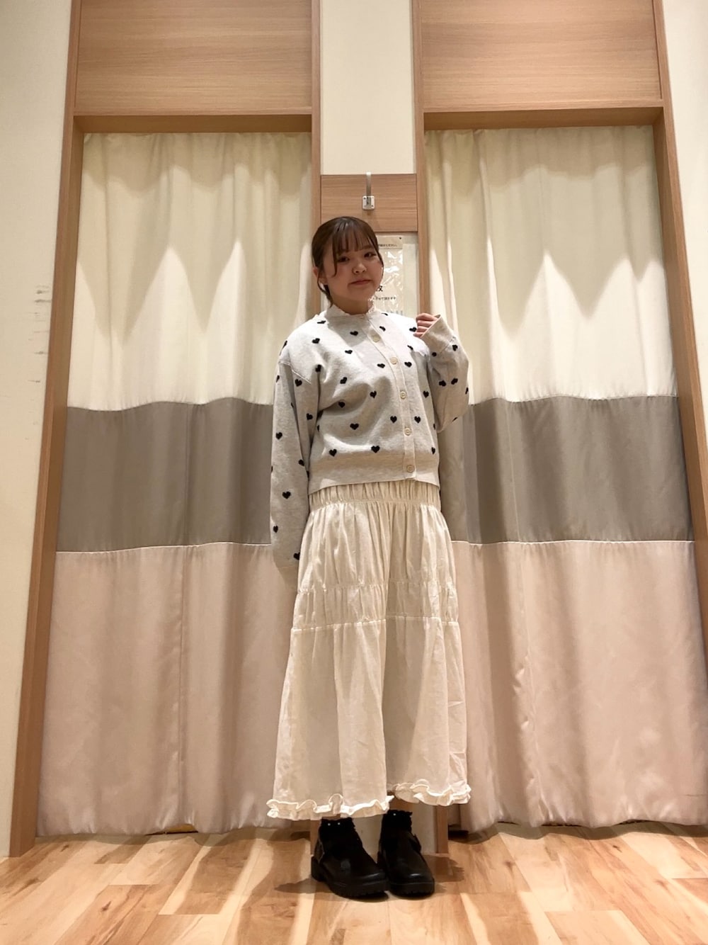 ホワイト系のスカート、ブラック系のその他シューズ、グレー系のカーディガン/ボレロを着用したレディースの冬コーディネートの1枚目の写真