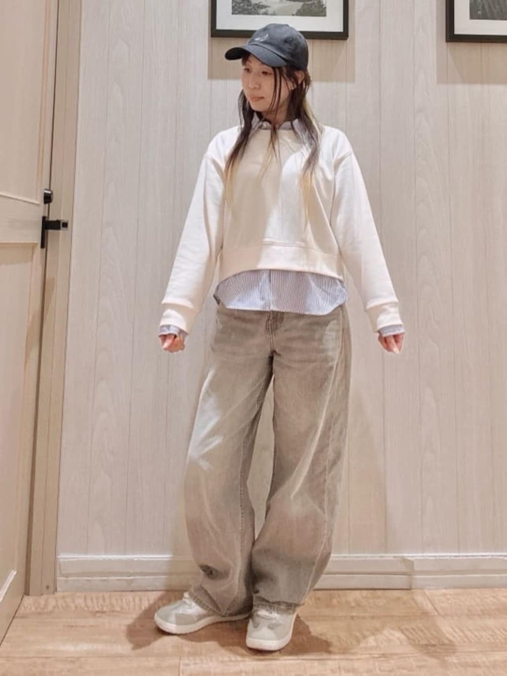 グレー系のデニムパンツ、ホワイト系のスウェット、シルバー系のスニーカーを着用したレディースの春コーディネートの1枚目の写真