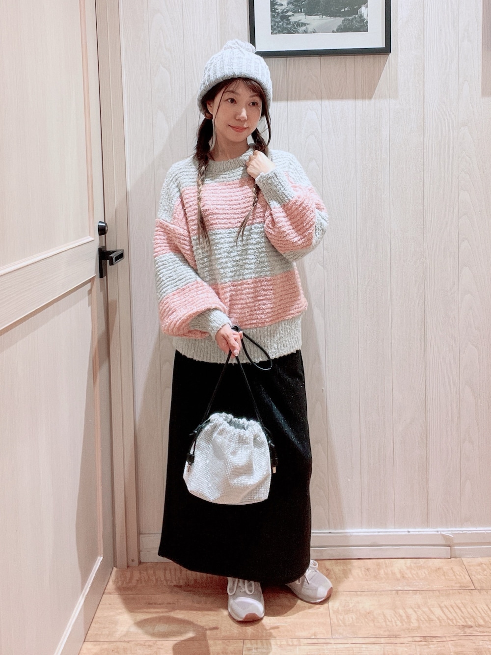 ピンク系のニット/セーター、シルバー系のショルダーバッグ、ブラック系のスカートを着用したレディースの秋コーディネートの1枚目の写真