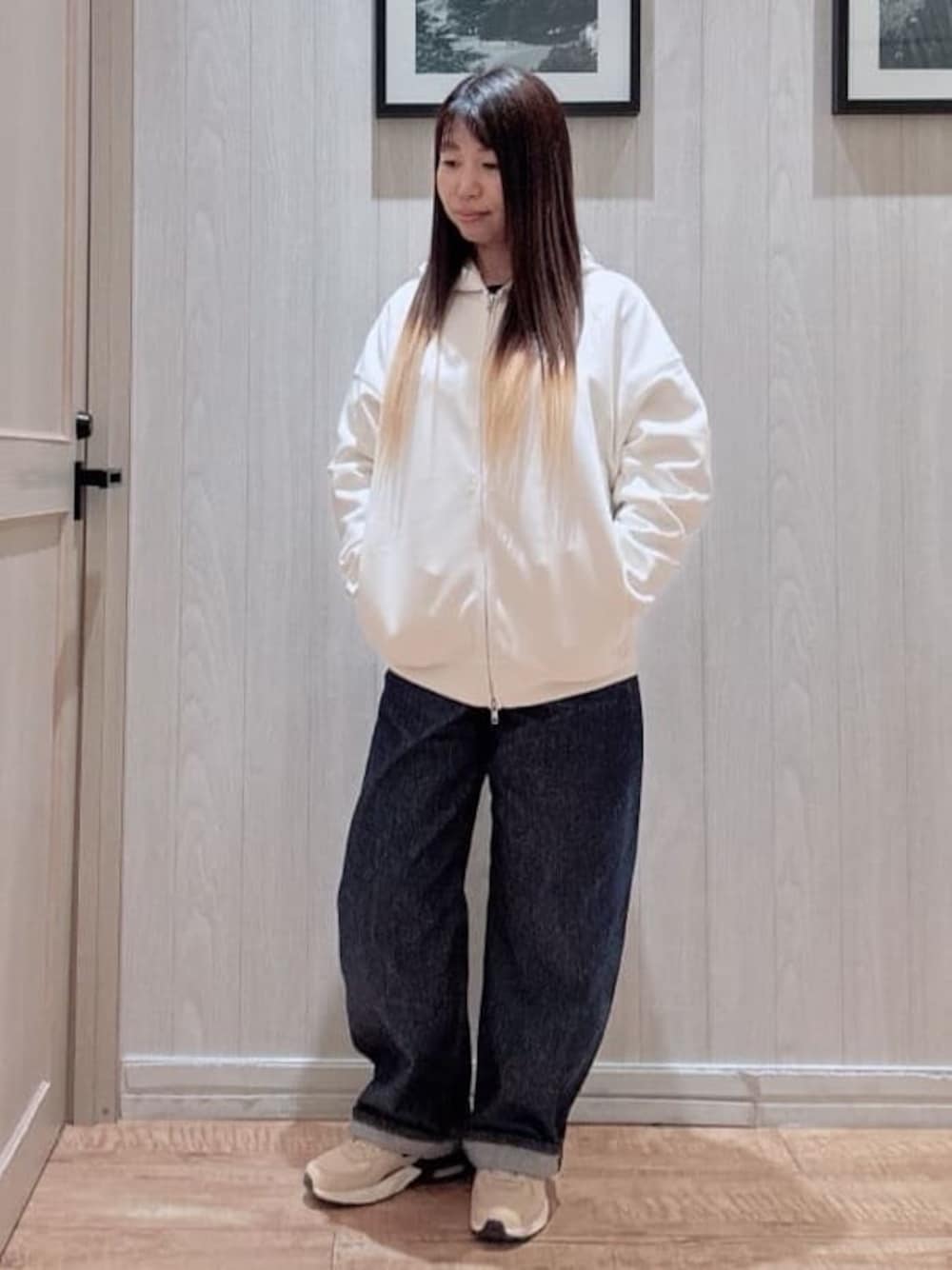 ホワイト系のパーカー、ブルー系のデニムパンツを着用したレディースの冬コーディネートの1枚目の写真