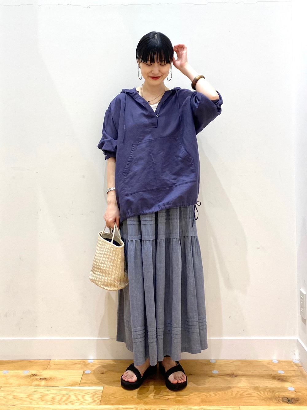 ブルー系のパーカー、ホワイト系のタンクトップ、グレー系のスカートを着用したレディースの春コーディネートの1枚目の写真