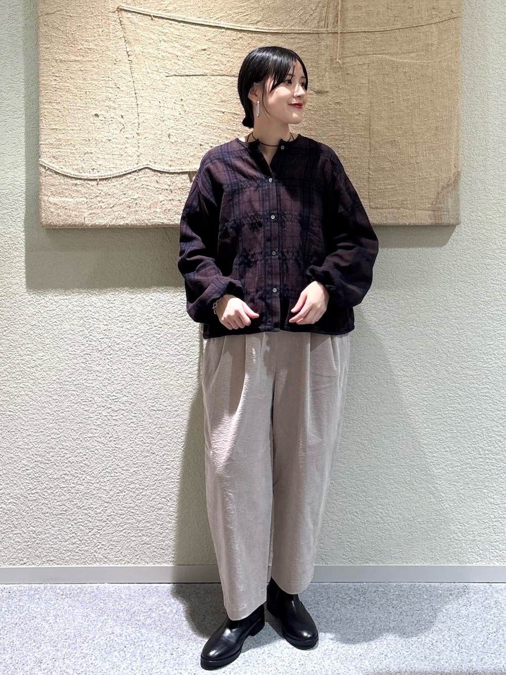 ブラウン系のカーディガン/ボレロ、グレー系のその他パンツ、ブラック系のブーツを着用したレディースの秋コーディネートの1枚目の写真