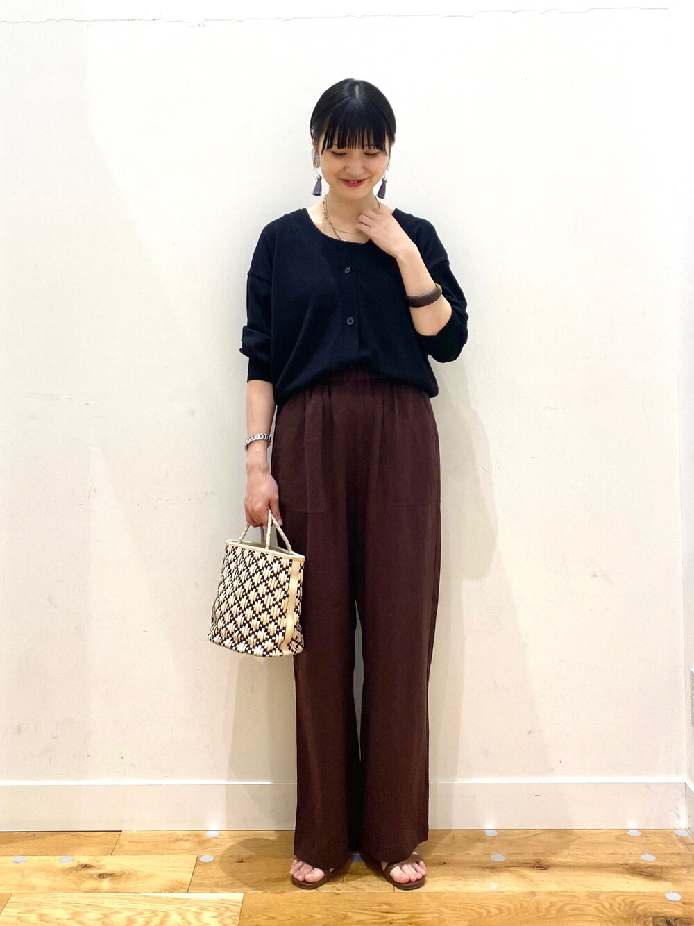 ブラック系のカーディガン/ボレロ、レッド系のその他パンツ、ブラウン系のサンダルを着用したレディースの春コーディネートの1枚目の写真