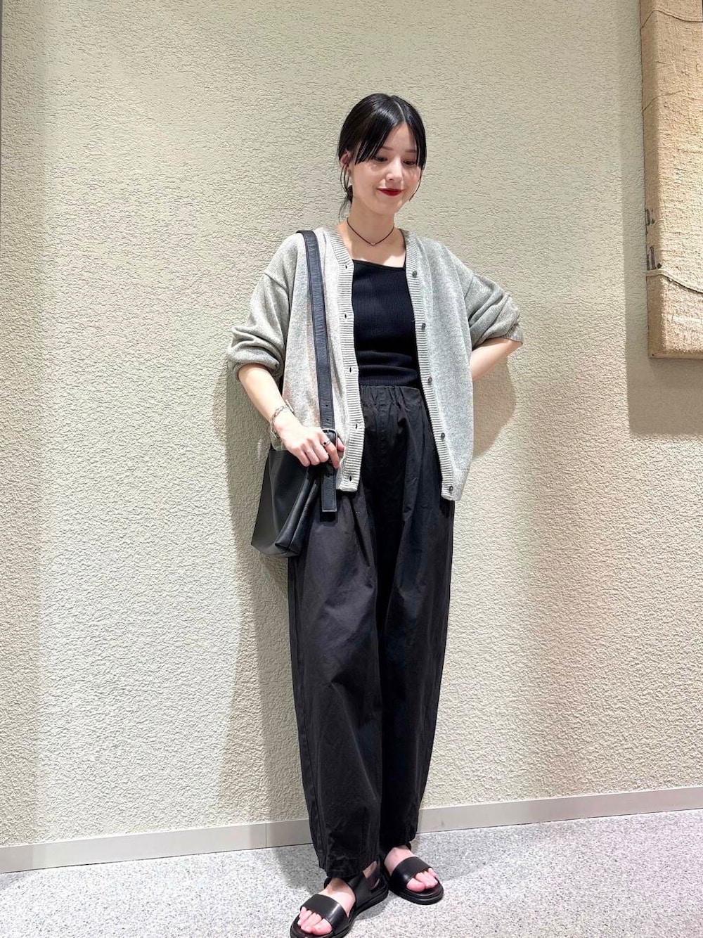 ブラック系のその他パンツ、グレー系のニット/セーターを着用したレディースの春コーディネートの1枚目の写真