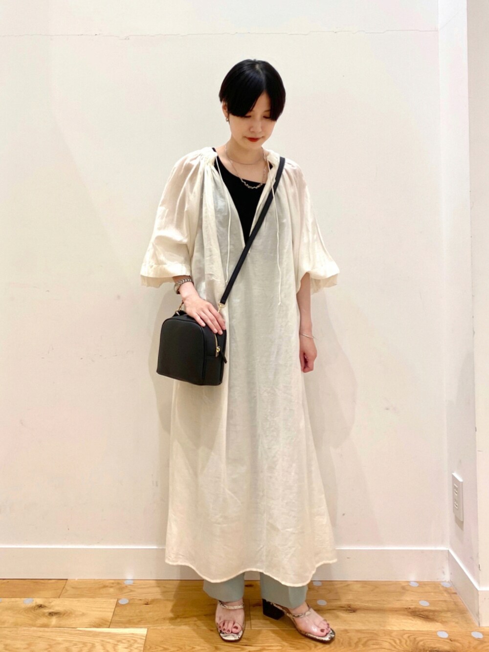 ホワイト系のワンピース、グリーン系のその他パンツ、ブラック系のショルダーバッグを着用したレディースの夏コーディネートの1枚目の写真