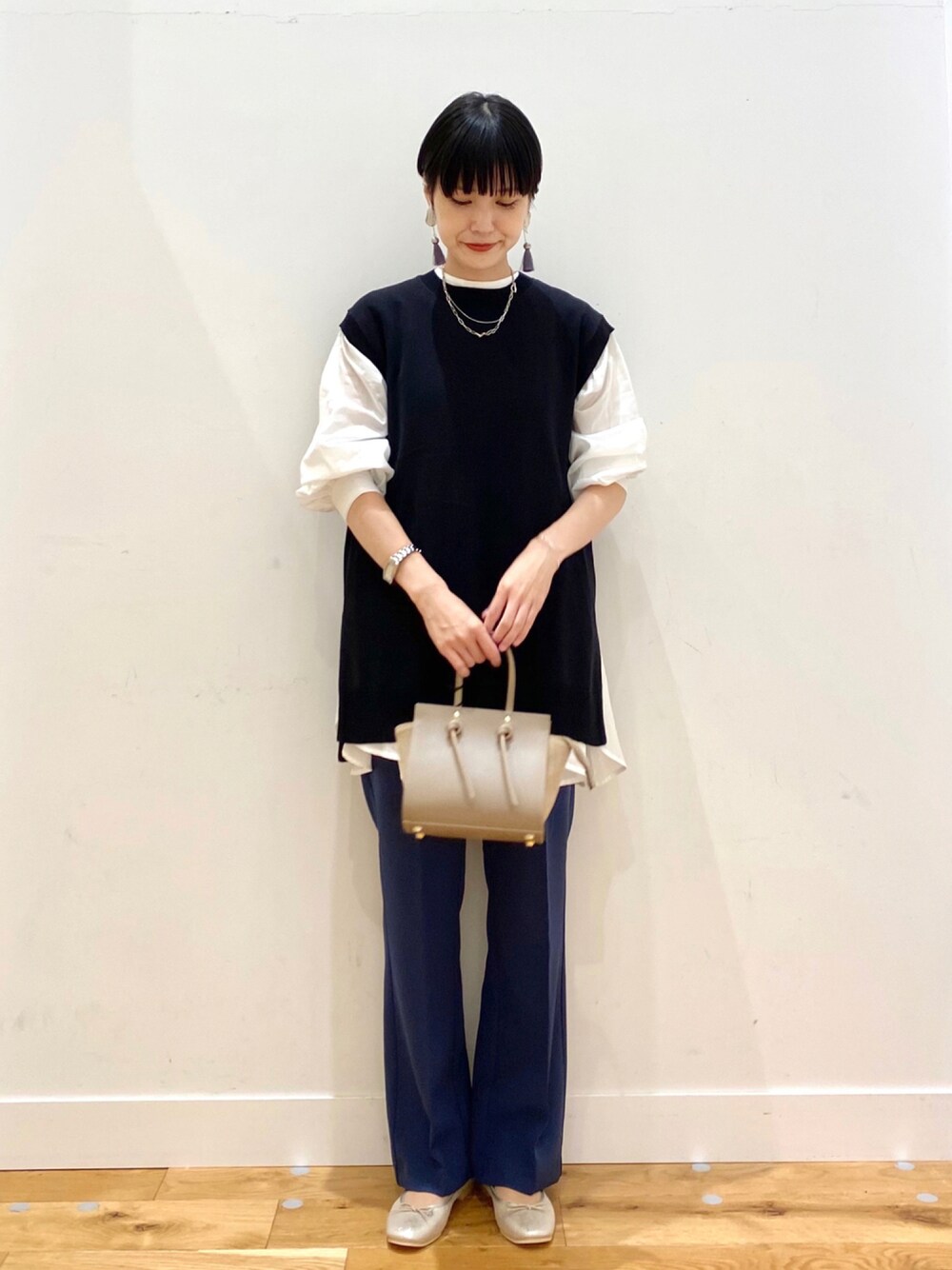 ホワイト系のシャツ/ブラウス、ブラック系のニット/セーター、ブルー系のその他パンツを着用したレディースの秋コーディネートの1枚目の写真