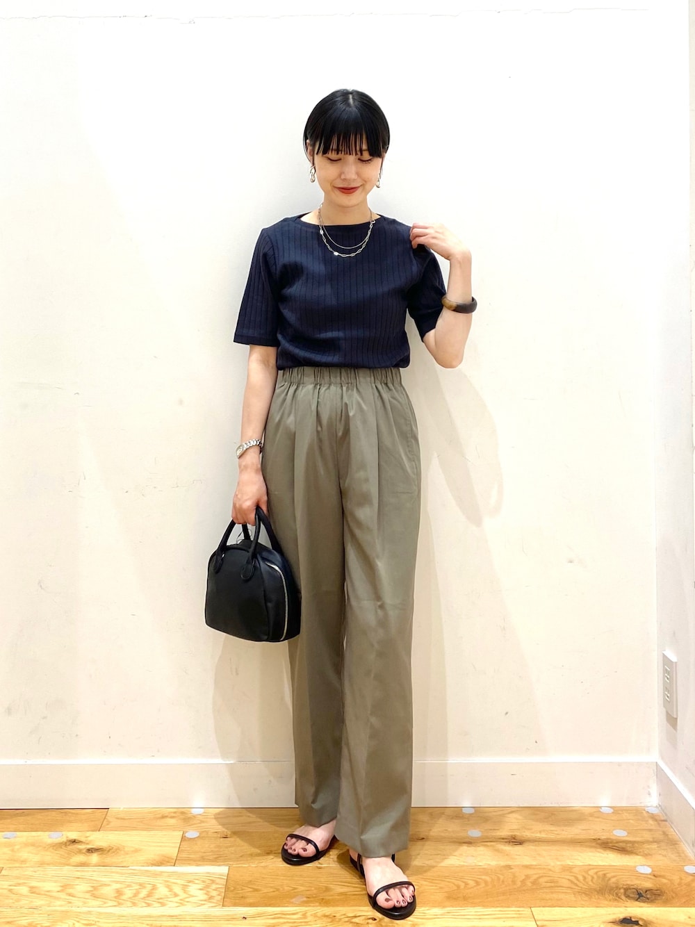 ブラック系のTシャツ/カットソー、グリーン系のその他パンツ、ブラック系のボストンバッグを着用したレディースの夏コーディネートの1枚目の写真