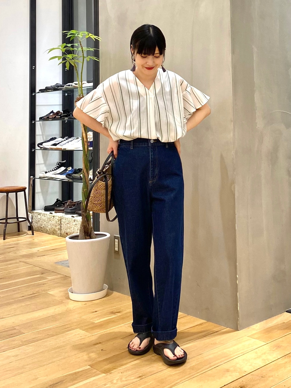 グリーン系のシャツ/ブラウス、ブルー系のデニムパンツ、ブラック系のサンダルを着用したレディースの春コーディネートの1枚目の写真