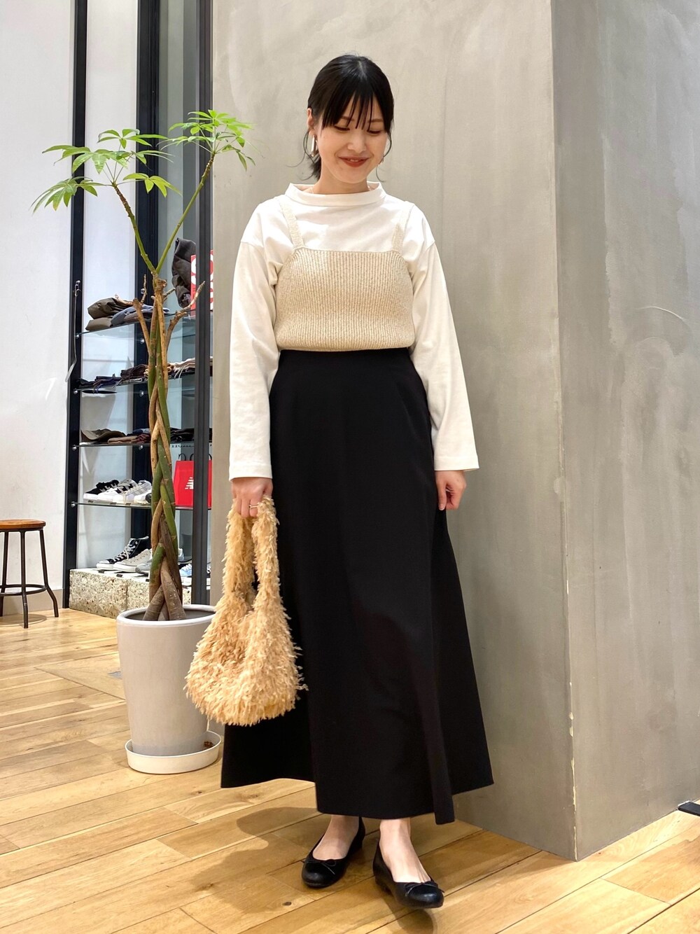 ホワイト系のTシャツ/カットソー、ブラック系のスカート、ベージュ系のショルダーバッグを着用したレディースの冬コーディネートの1枚目の写真