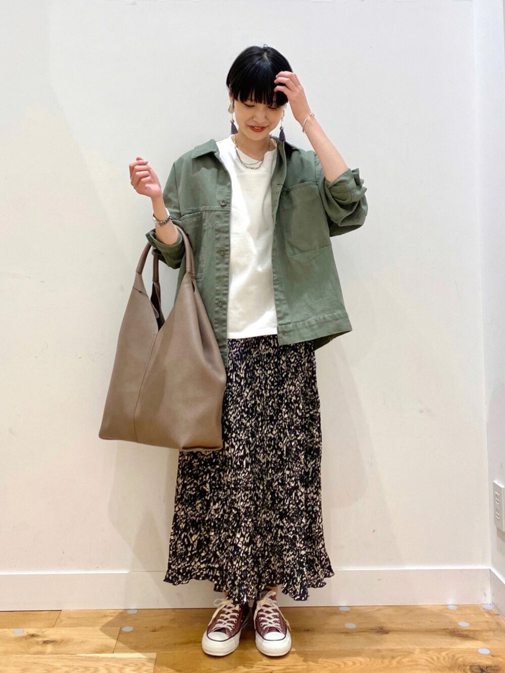 グリーン系のその他アウター、ホワイト系のTシャツ/カットソー、ブラック系のスカートを着用したレディースの秋コーディネートの1枚目の写真