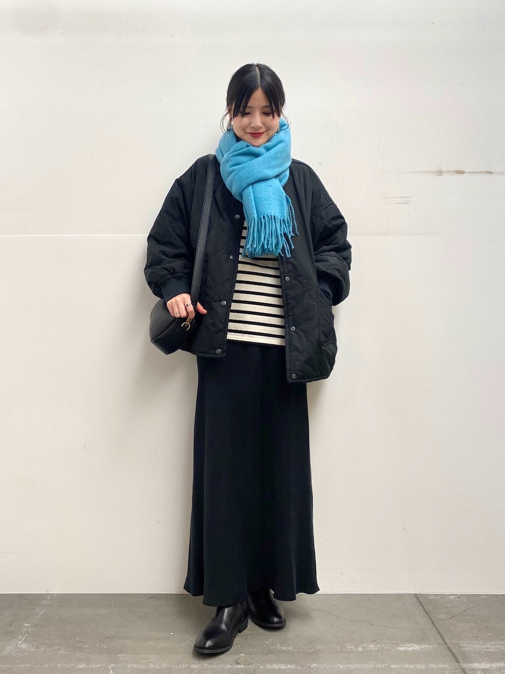 ブラック系のブルゾン、ホワイト系のTシャツ/カットソー、ブラック系のスカートを着用したレディースの秋コーディネートの1枚目の写真