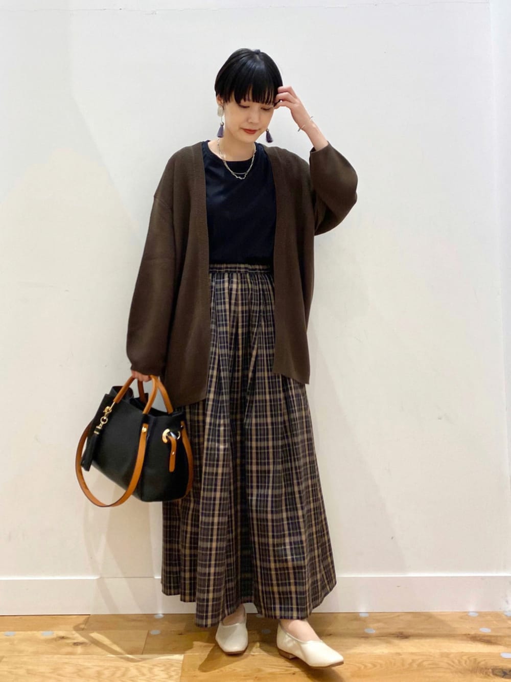 グリーン系のカーディガン/ボレロ、ブラック系のTシャツ/カットソー、その他のスカートを着用したレディースの秋コーディネートの1枚目の写真