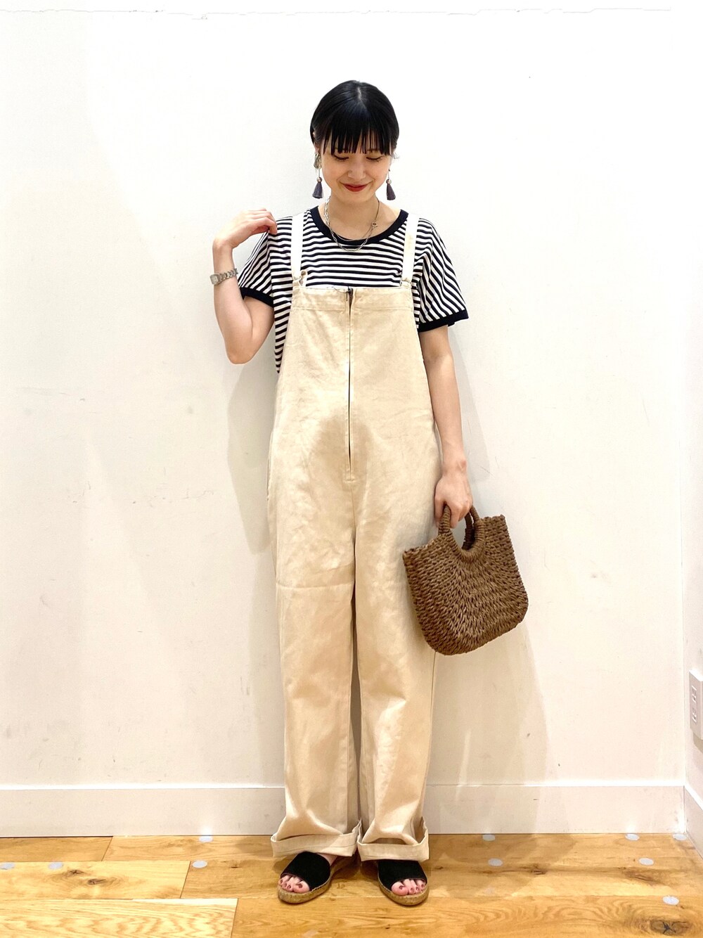 ホワイト系のTシャツ/カットソー、ホワイト系のサロペット/オーバーオール、ブラウン系のハンドバッグを着用したレディースの春コーディネートの1枚目の写真