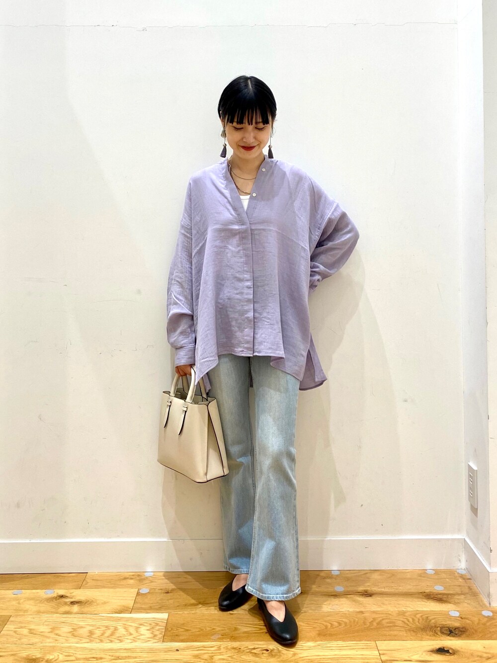 パープル系のシャツ/ブラウス、ブルー系のデニムパンツ、ホワイト系のトートバッグを着用したレディースの秋コーディネートの1枚目の写真