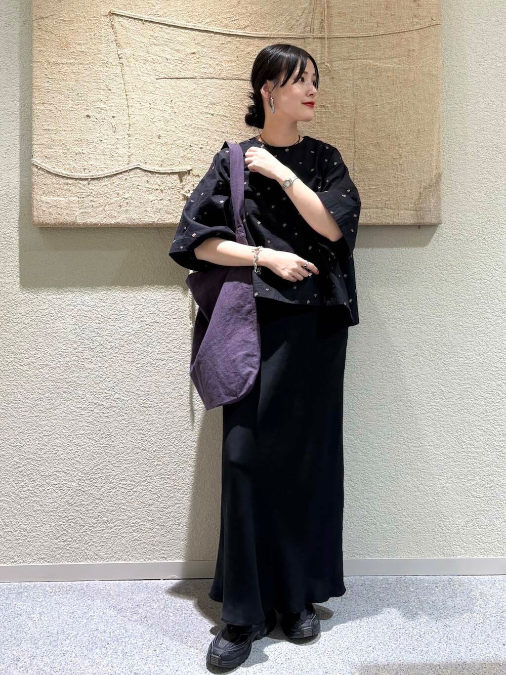 ブラック系のスカート、パープル系のトートバッグ、ブラック系のシャツ/ブラウスを着用したレディースの春コーディネートの1枚目の写真