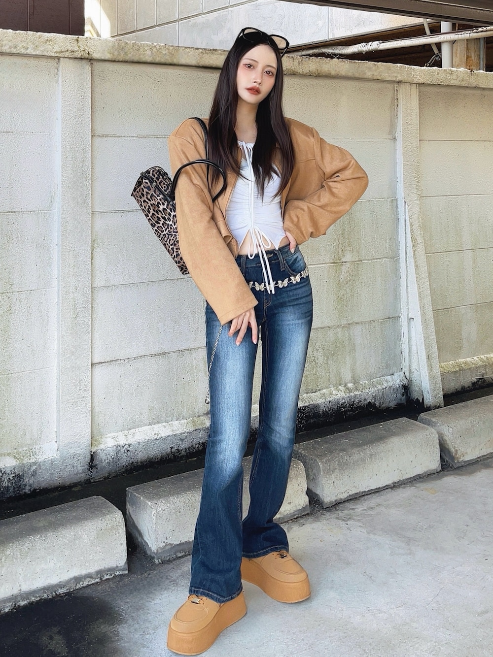 ベージュ系のジャケット/アウター、ホワイト系のトップス、ブルー系のデニムパンツを着用したレディースの秋コーディネートの1枚目の写真