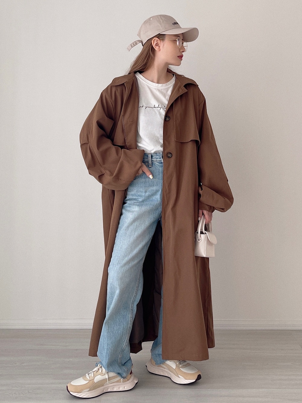 「スニーカー、キャップ、ロンT、春コーデ、トレンチコート、ビッグシルエット、ボリューム袖、ブラウン、ロゴT、デニムパンツ、デニムコーデ、デニム、ベージュ、厚底シューズ、アウトドアスタイル」｜「etadeの【etade】soutien collar trench coat etdwz22s002（トレンチコート、ブラウン系）」を使った、T Λ Eさん（レディース・158cm）の春コーディネートの1枚目の写真