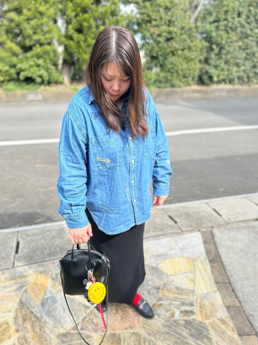 ブルー系のシャツ/ブラウス、ブラック系のスカート、ブラック系のショルダーバッグを着用したレディースの春コーディネートの1枚目の写真