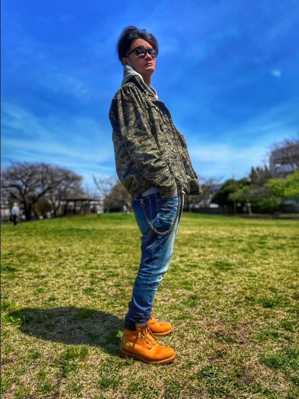 その他のミリタリージャケット、グレー系のパーカー、ブルー系のデニムパンツを着用したメンズの春コーディネートの1枚目の写真