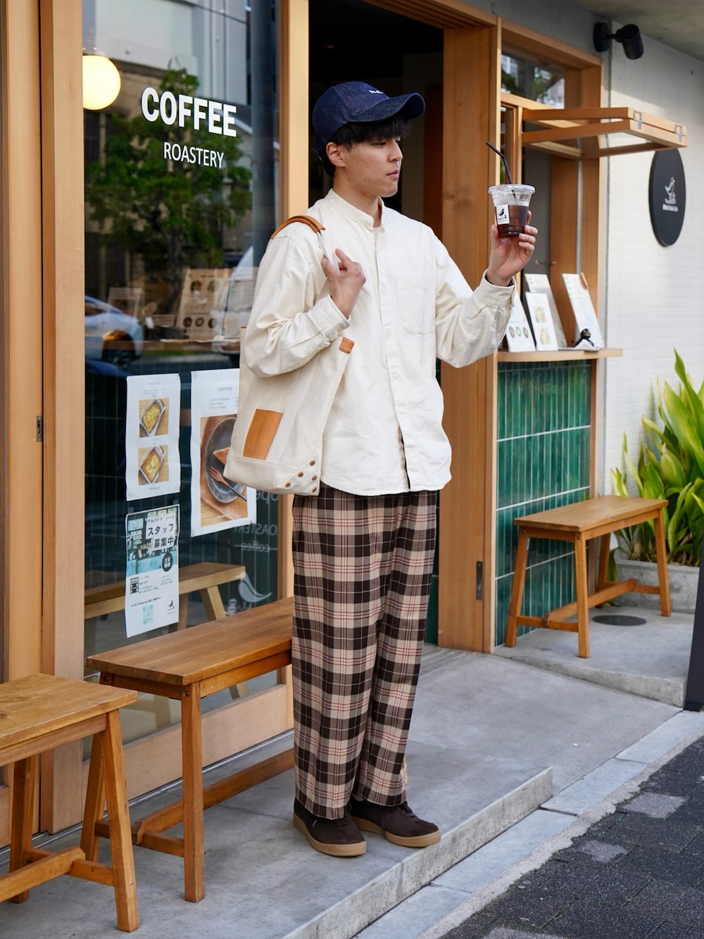 ブラウン系のスニーカー、ブラウン系のパンツ、ベージュ系のトートバッグを着用したメンズの春コーディネートの1枚目の写真