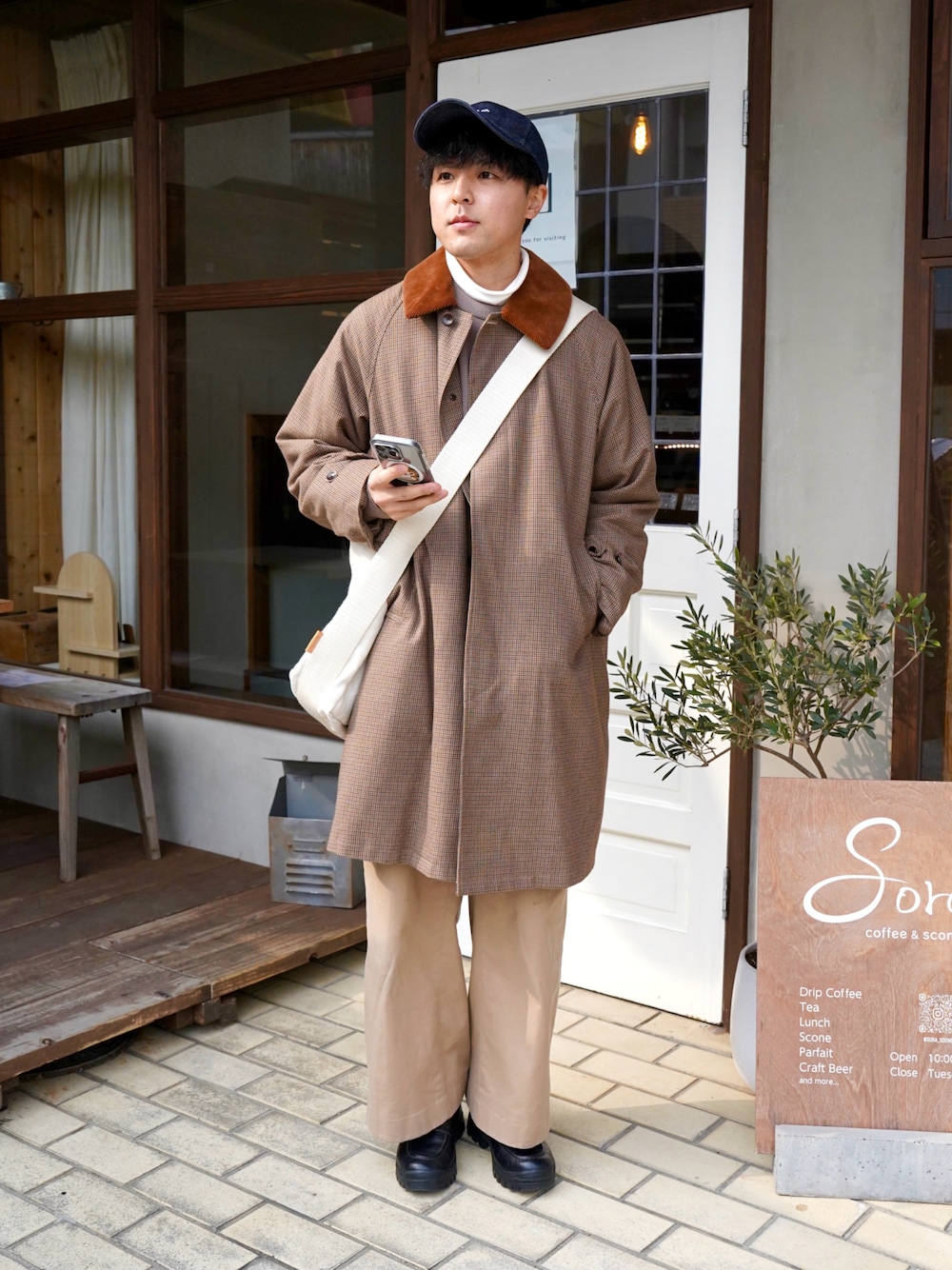 ブラック系のその他シューズ、ベージュ系のショルダーバッグ、ブラウン系のステンカラーコートを着用したメンズの冬コーディネートの1枚目の写真