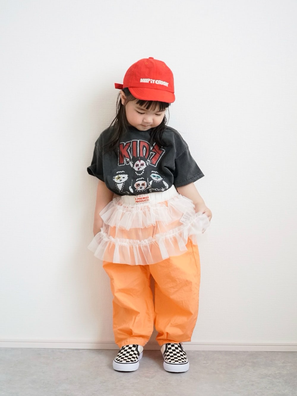 ブラック系のTシャツ/カットソー、オレンジ系のその他パンツ、ホワイト系のスカートを着用したキッズの春コーディネートの1枚目の写真