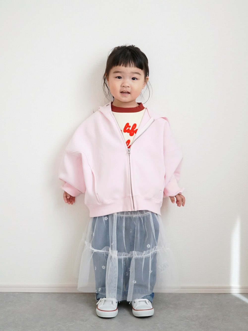 ピンク系のパーカー、ホワイト系のTシャツ/カットソー、ブルー系のデニムパンツを着用したキッズの春コーディネートの1枚目の写真