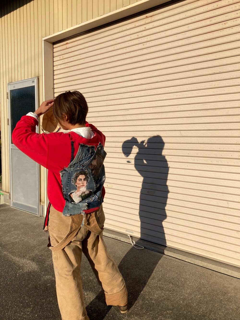 レッド系のスウェット、ブラウン系のブーツを着用したレディースの冬コーディネートの1枚目の写真