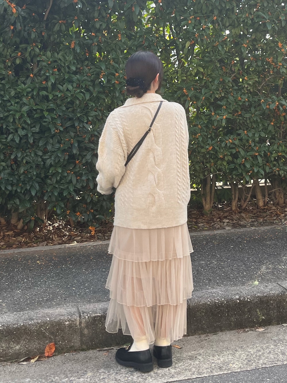 ベージュ系のニット/セーター、ベージュ系のスカート、ブラック系のバッグを着用したレディースの秋コーディネートの1枚目の写真