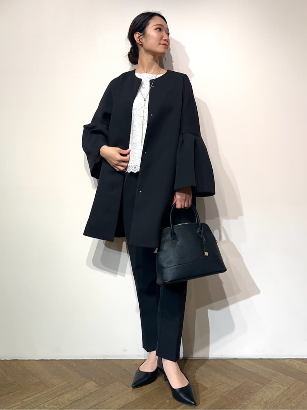 ブルー系のノーカラーコート、ホワイト系のシャツ/ブラウス、ブラック系のその他パンツを着用したレディースの冬コーディネートの1枚目の写真