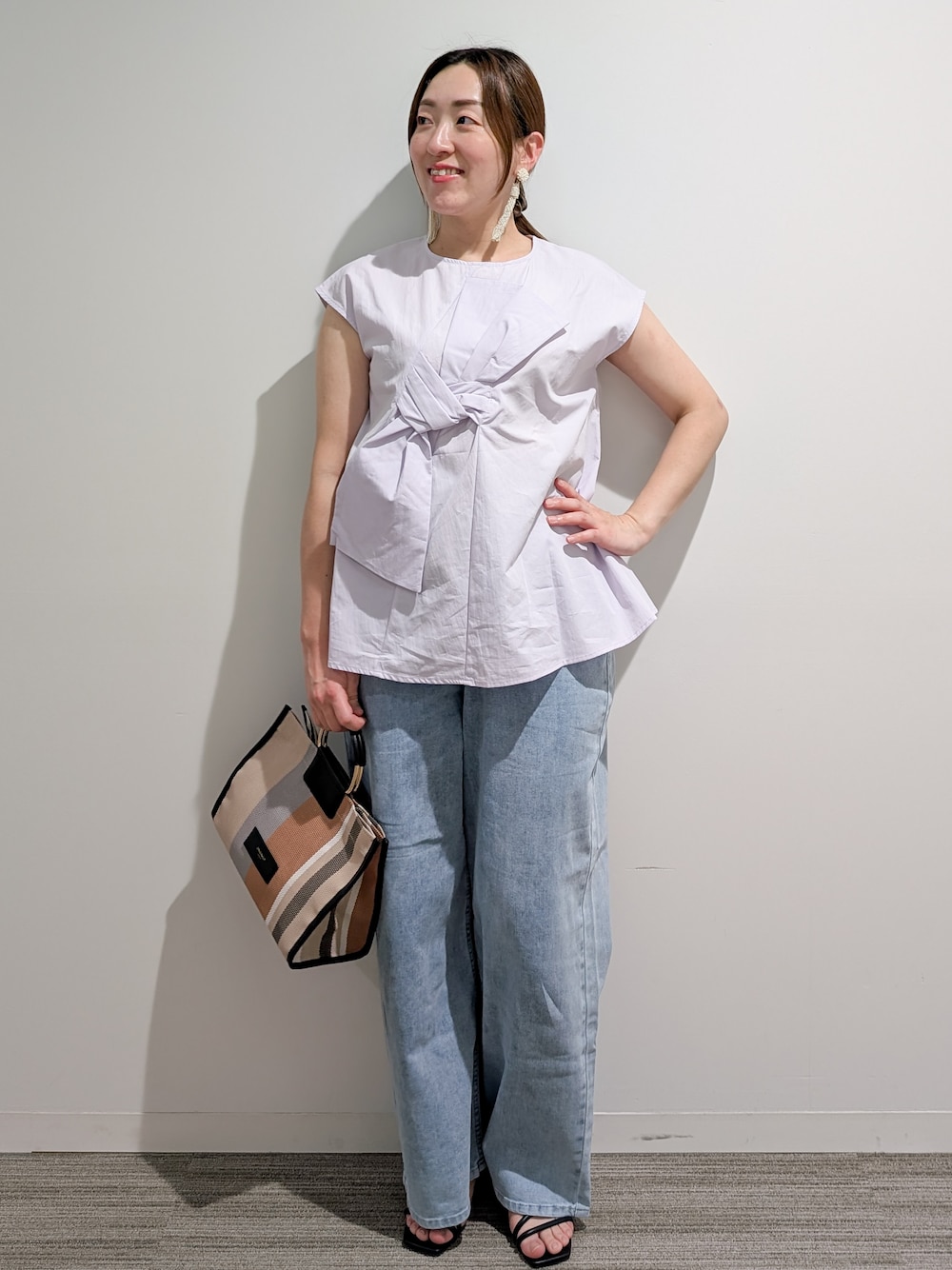 パープル系のシャツ/ブラウス、ブルー系のデニムパンツ、ブラック系のトートバッグを着用したレディースの夏コーディネートの1枚目の写真