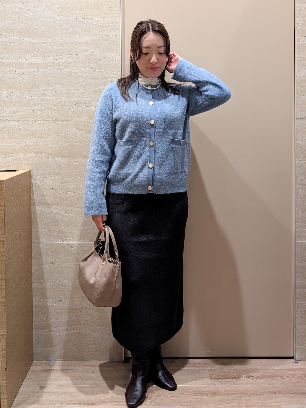 ブルー系のカーディガン/ボレロ、グレー系のスカート、ベージュ系のトートバッグを着用したレディースの秋コーディネートの1枚目の写真