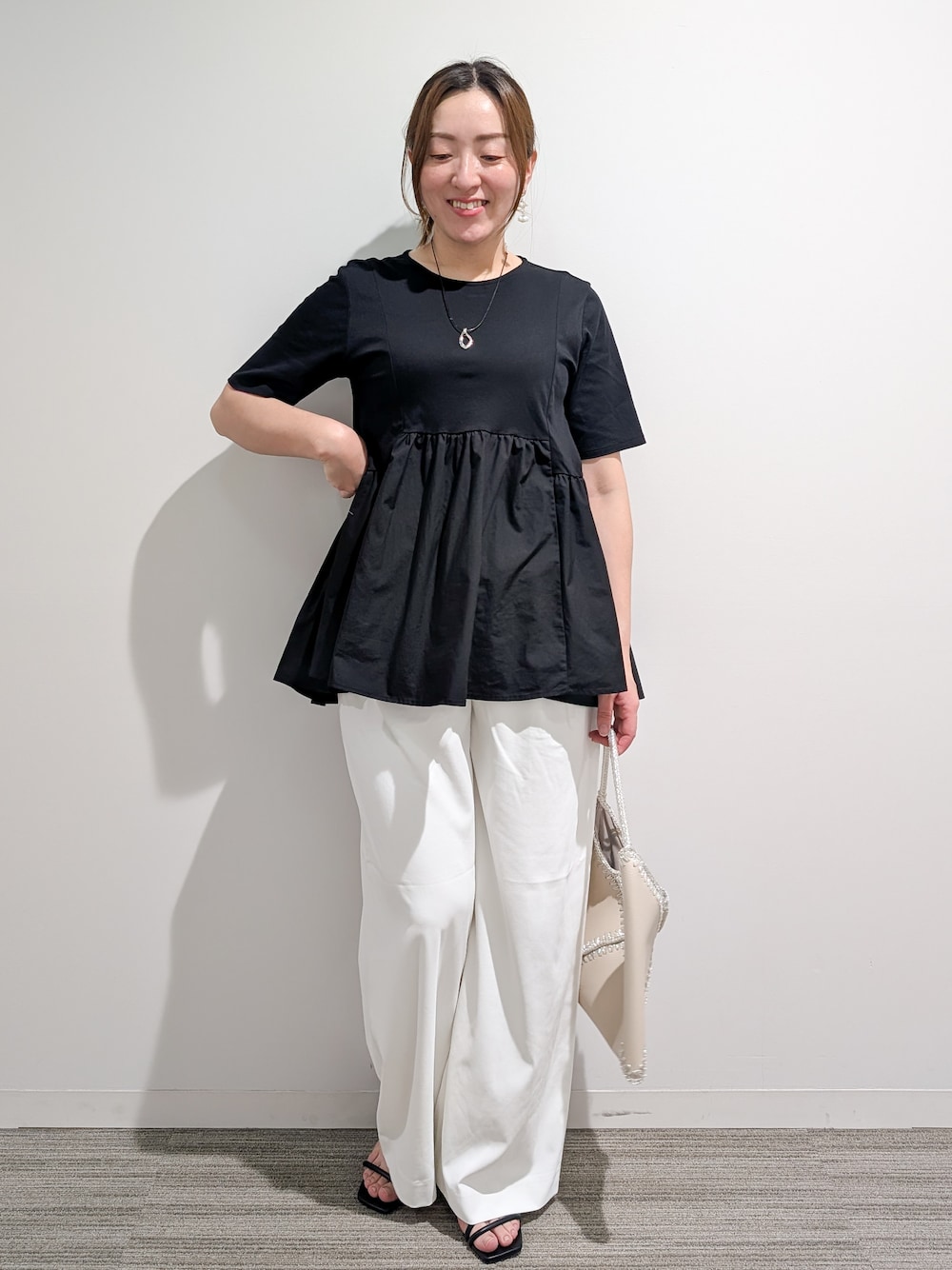 ブラック系のTシャツ/カットソー、ホワイト系のその他パンツ、ホワイト系のハンドバッグを着用したレディースの夏コーディネートの1枚目の写真