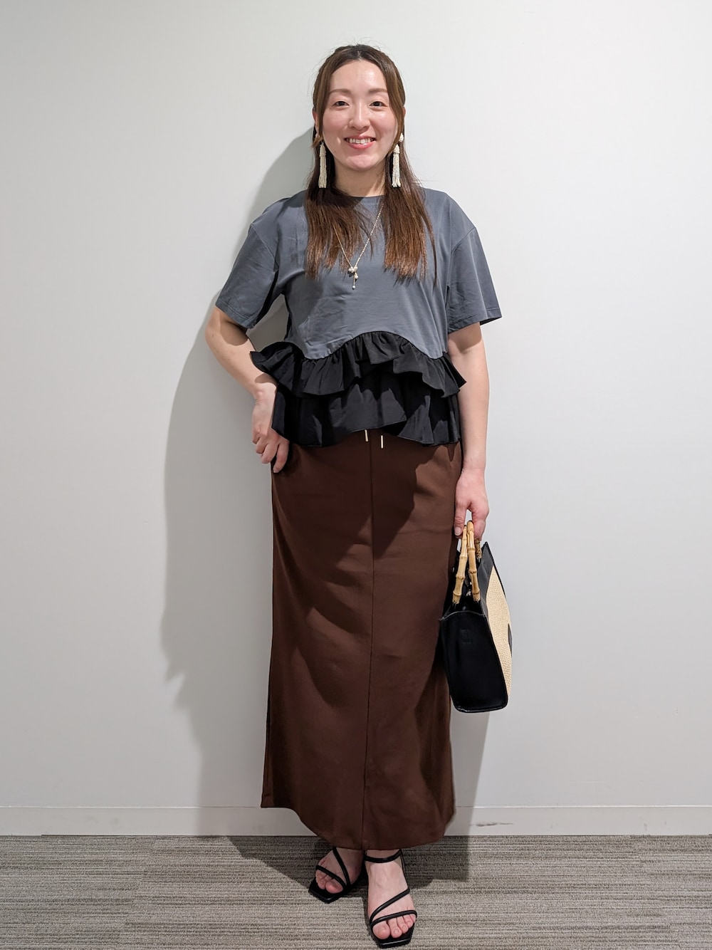 グレー系のTシャツ/カットソー、ブラウン系のスカート、ブラック系のトートバッグを着用したレディースの夏コーディネートの1枚目の写真