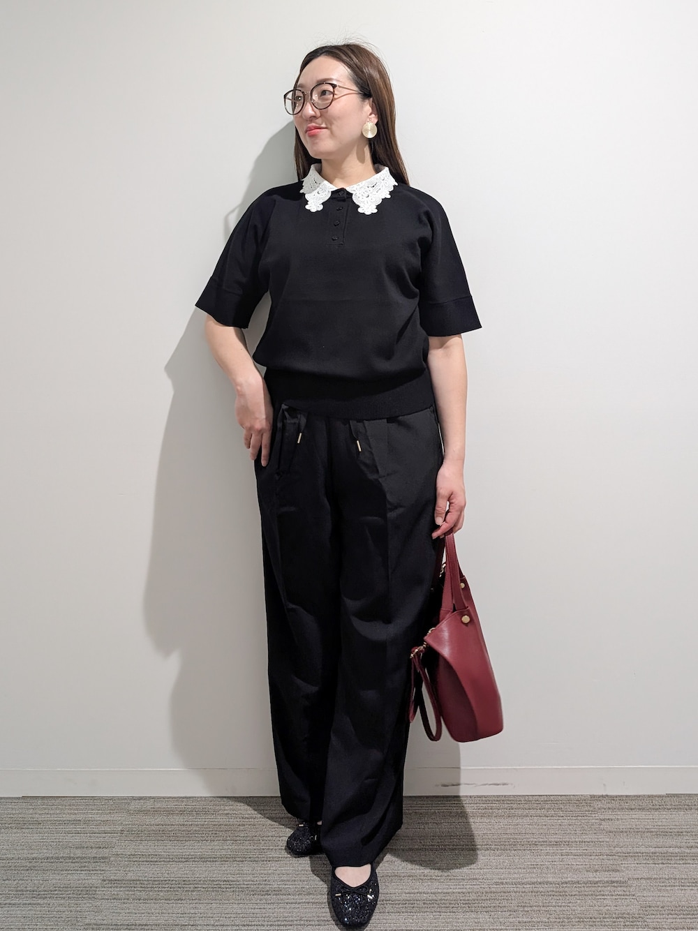 ブラック系のニット/セーター、ブラック系のその他パンツ、レッド系のショルダーバッグを着用したレディースの秋コーディネートの1枚目の写真