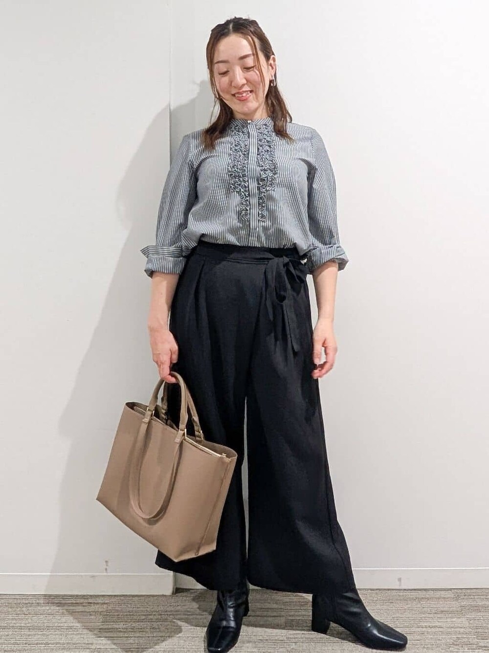 グレー系のシャツ/ブラウス、ブラック系のその他パンツ、ベージュ系のトートバッグを着用したレディースの秋コーディネートの1枚目の写真
