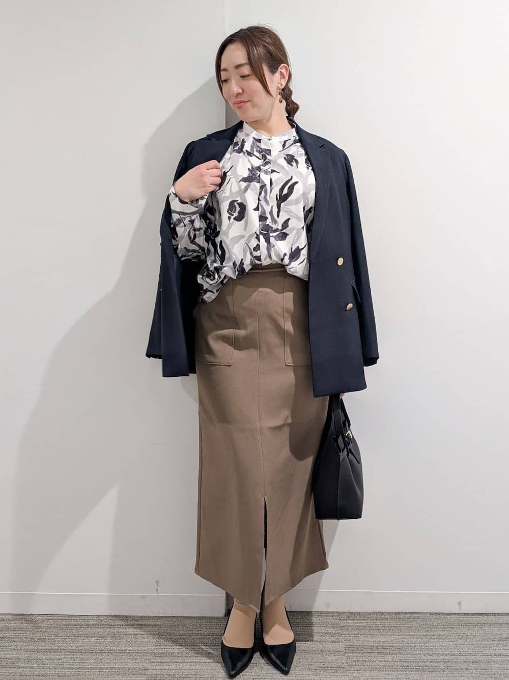 ブルー系のシャツ/ブラウス、ブラック系のパンプス、ブラウン系のスカートを着用したレディースの春コーディネートの1枚目の写真