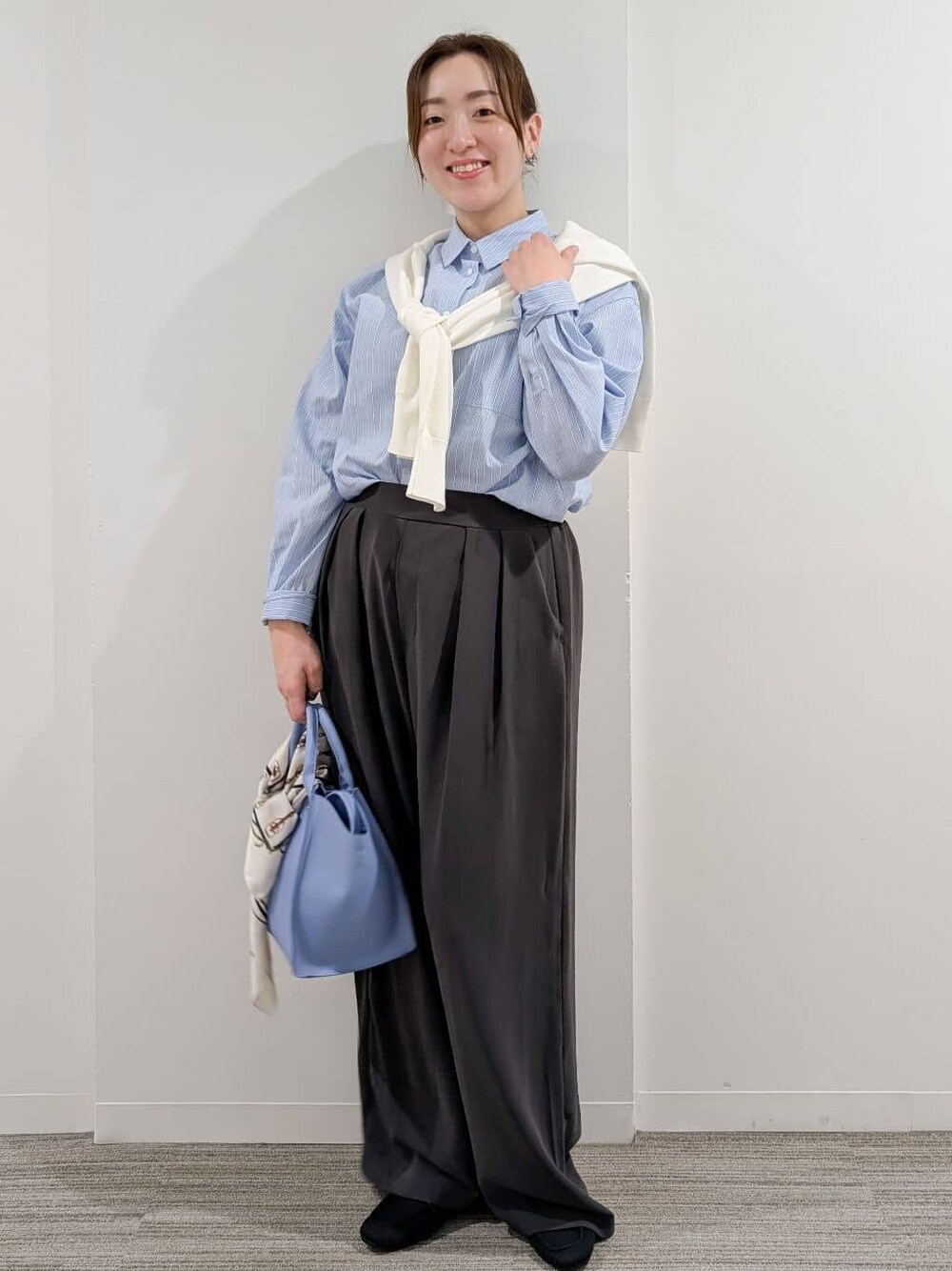 ブルー系のシャツ/ブラウス、ホワイト系のニット/セーター、グレー系のその他パンツを着用したレディースの冬コーディネートの1枚目の写真