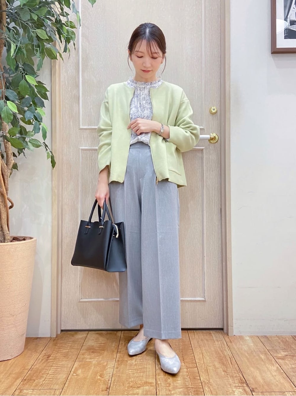 イエロー系のカーディガン/ボレロ、ベージュ系のシャツ/ブラウス、グレー系のその他パンツを着用したレディースの春コーディネートの1枚目の写真