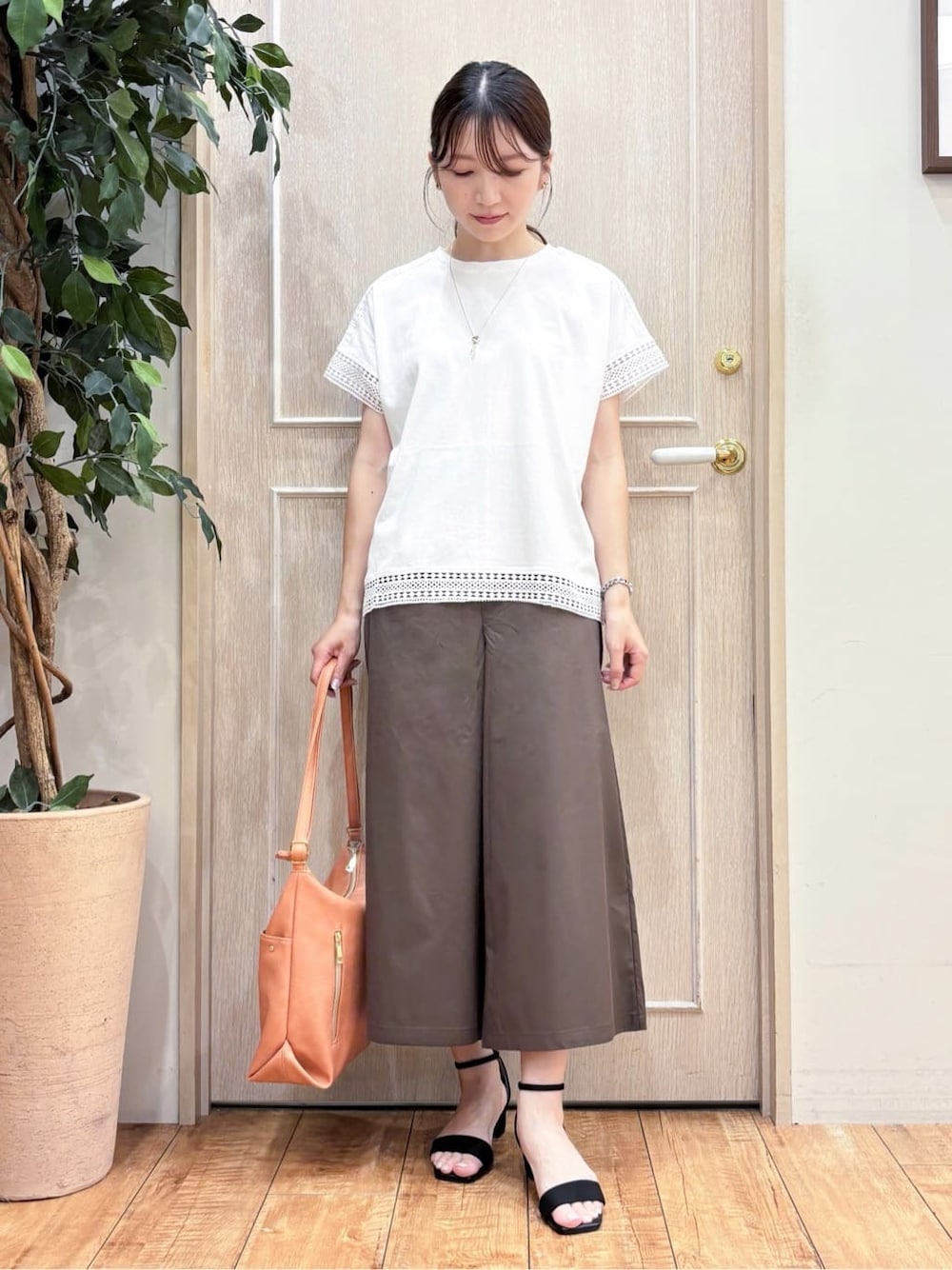 ホワイト系のTシャツ/カットソー、ブラウン系のその他パンツ、ブラック系のサンダルを着用したレディースの夏コーディネートの1枚目の写真