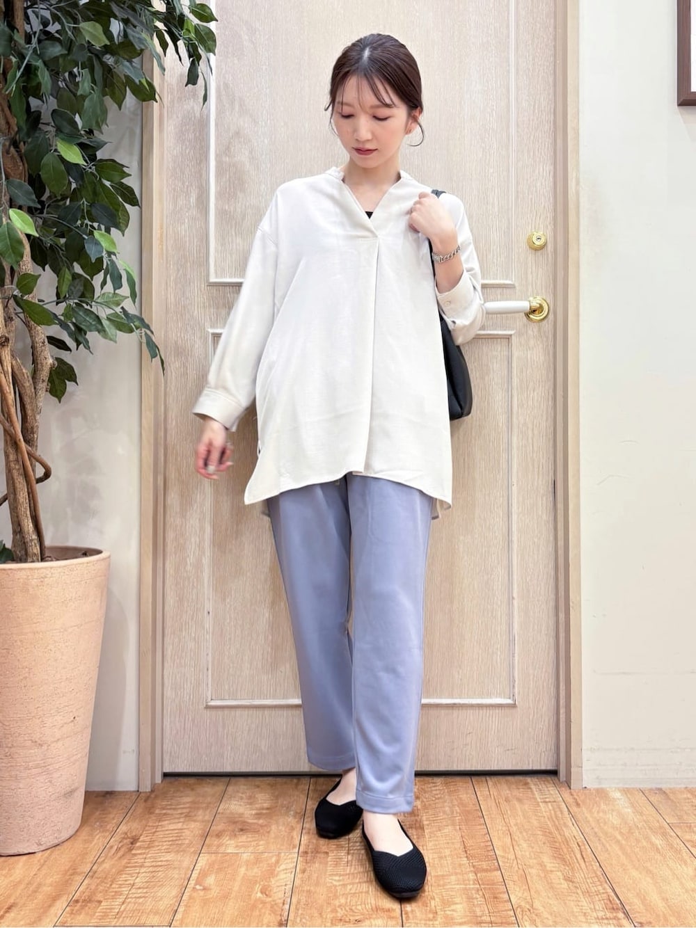 ベージュ系のチュニック、ブルー系のその他パンツ、ブラック系のパンプスを着用したレディースの春コーディネートの1枚目の写真
