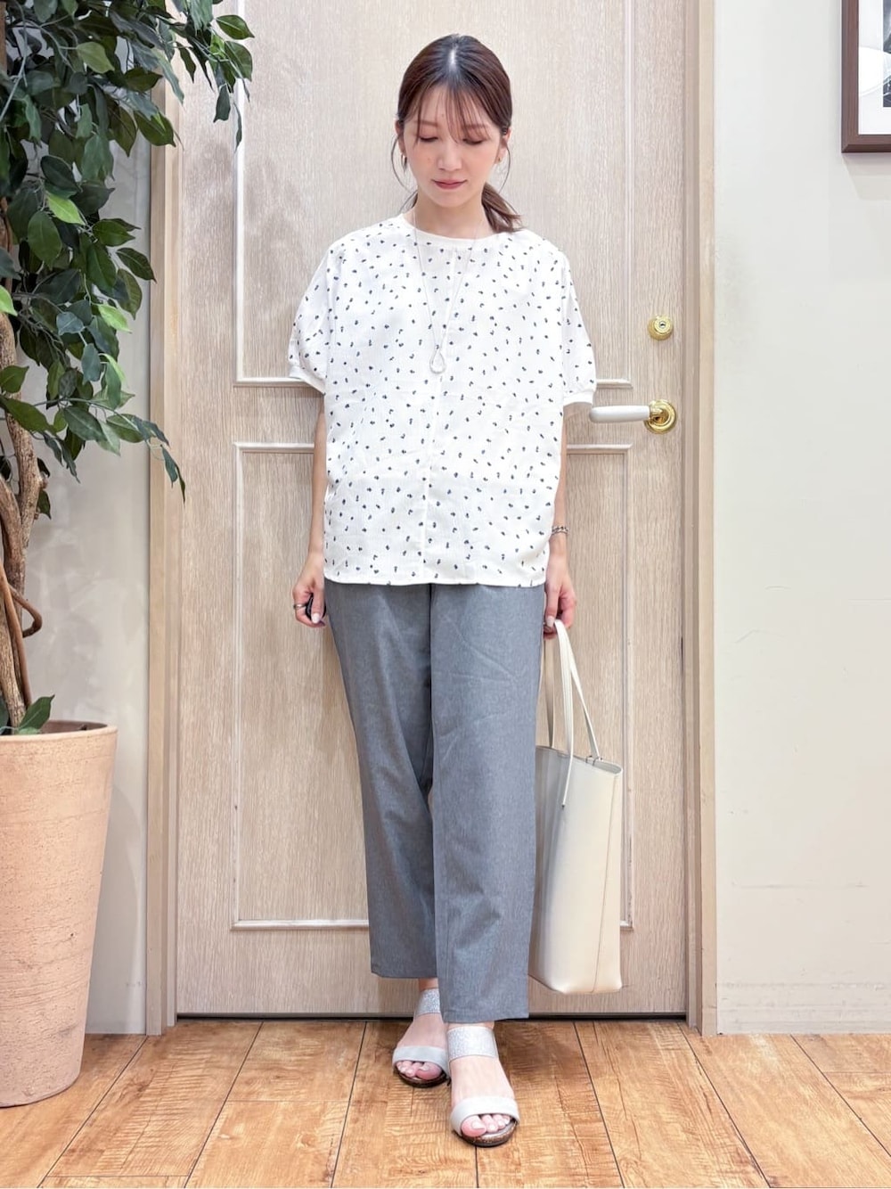 ホワイト系のシャツ/ブラウス、グレー系のその他パンツ、シルバー系のサンダルを着用したレディースの夏コーディネートの1枚目の写真