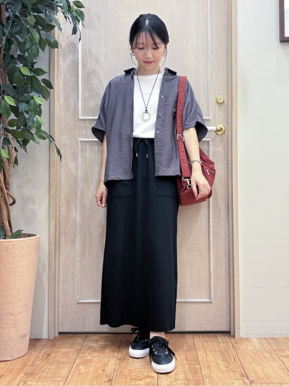 ブラウン系のシャツ/ブラウス、ホワイト系のTシャツ/カットソー、ブラック系のスカートを着用したレディースの秋コーディネートの1枚目の写真