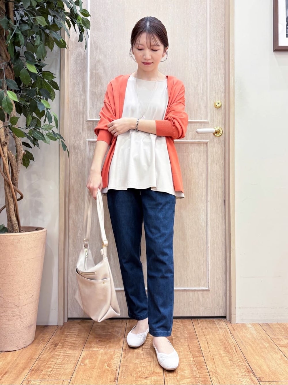 オレンジ系のカーディガン/ボレロ、ベージュ系のTシャツ/カットソー、ブルー系のその他パンツを着用したレディースの春コーディネートの1枚目の写真
