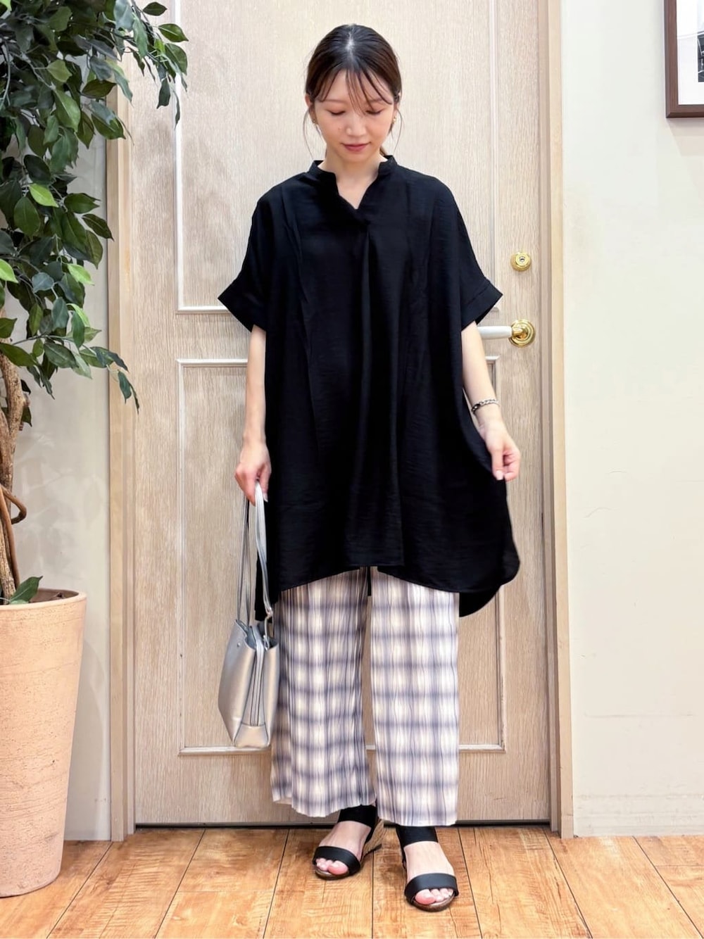 ブラック系のチュニック、グレー系のその他パンツ、ブラック系のサンダルを着用したレディースの夏コーディネートの1枚目の写真