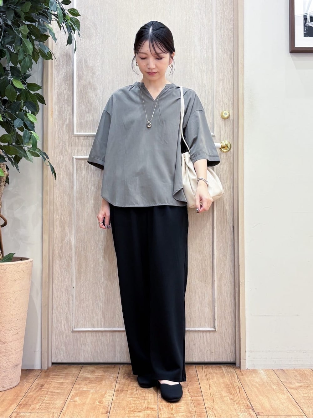 グリーン系のシャツ/ブラウス、ブラック系のその他パンツ、ブラック系のパンプスを着用したレディースの秋コーディネートの1枚目の写真